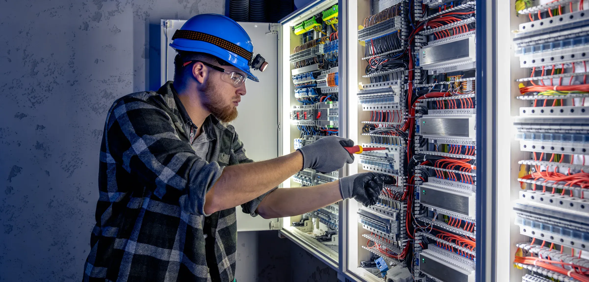 David Doyle Electrical technician wiring a lit commercial switchboard