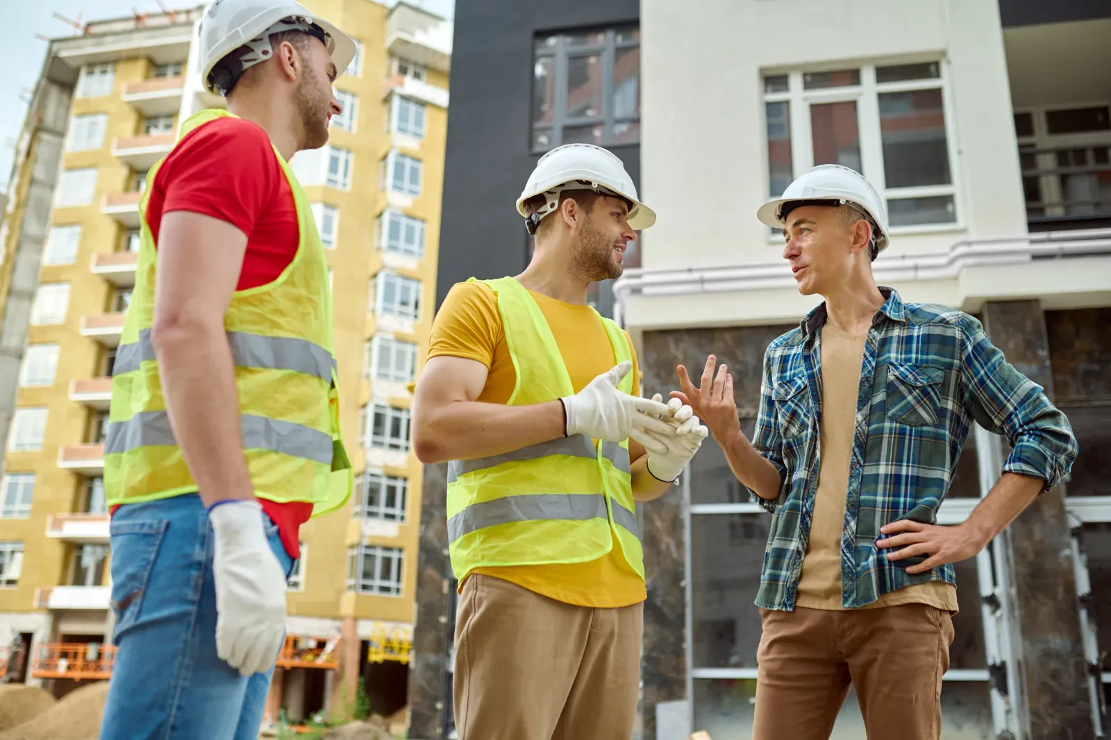Electrical engineers and site workers reviewing plans on a construction site